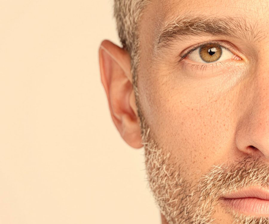 The left half of a man's face photographed under a warm kitchen bulb.
